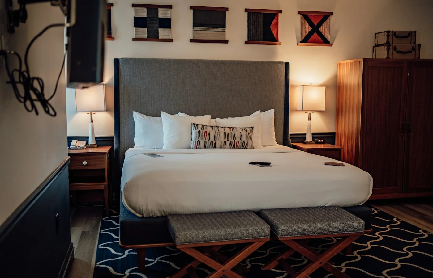 A warmly lit guest room with a king bed and wooden furniture