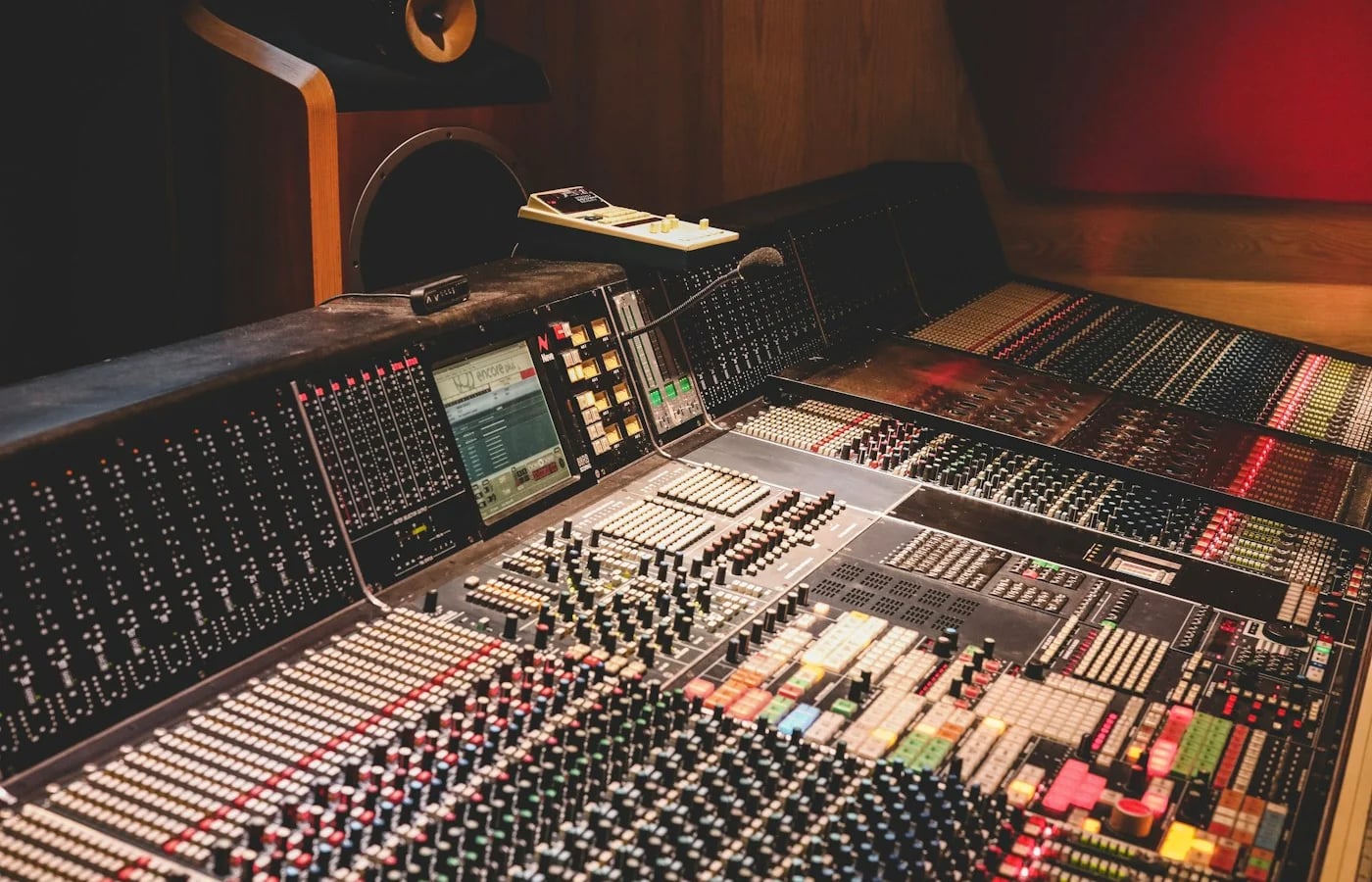 An audio mixing console in a wood-lined recording studio